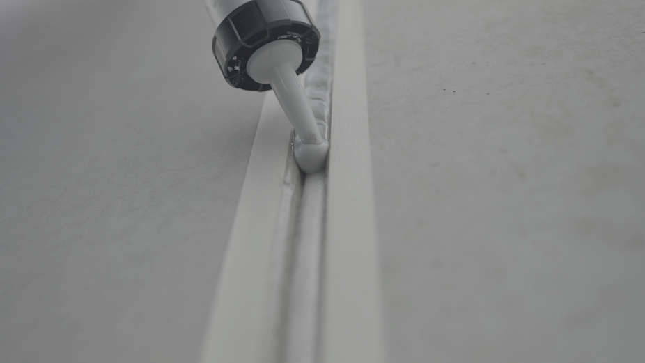 close-up black and white, gun nozzle into horizontal joint